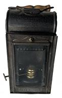 RM1479 Small Railroad Lantern embossed on front with "D.R.G.M. 1861" - which is a marking depicting an early German Copyright. Front panel slides up to allow access to fill the internal oil / paraffin burner. There is a small key-like latch on the back that slides the internal reflector aside enough to allow access to light the wick through a small hole. Sturdy wire bail on top with wooden handle and also a metal hook-style handle on back - either of which can be used for carrying or hanging purposes. Great working condition. Measurements:2 3/4" wide x 2 1/2" deep x 5 1/2" tall (7 1/2" tall with handle up)