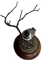 M292 Lifelike Folk Art carving of a baby Black-capped Chickadee perched upon a branch signed and dated Rosalyn Leach Daisey 1989 on bottom. All wooden, hand carved and painted, with exceptional details. Rosalyn Leach Daisey (b. 1945) transitioned from a registered nurse into a renowned Delaware-based woodcarver. Approximate overall measurements: 4 ¾ diameter bottom x ~8 across widest point x ~5 tall at tallest point.