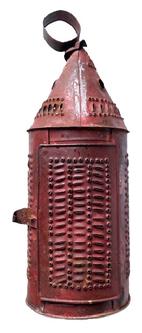 **SOLD** K1568 Late 18th - early 19th century Pennsylvania punched tin lantern retaining an old red painted surface. Symmetrically punched and pierced circular patterns of dots and dashes framed by a very visually appealing border adorns the sides, while the hinged door bears symmetrical rows of dots dashes. Hinged door opens for easy access to interior candle socket. Attached round tin handle at the top for carrying / hanging. Approximate measurements:  5 ¼ diameter x approximately 14 ¾ tall with ring.  