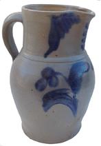 S399  Cobalt-Decorated Stoneware Pitcher,Baltimore, MD origin, circa 1875, ovoid-bodied pitcher with tooled rim and applied strap handle, decorated with a brushed cobalt flower extending from a groups of leaves.   brushwork flanking the spout.   chips to the base Stoneware pitcher Baltimore , Peter Hermann