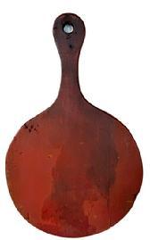 M13 19th century Pennsylvania round wooden cutting board with lollipop shaped top bearing remnants of red wash painted surface and natural patina on each side with evidence of chop / slice marks from years of use. The shaped top has a hole for hanging purposes. The wood is pine. Measurements: 20" long x 16" wide x 1" thick.