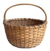 M157 Basket featuring its natural surface with a single wrapped, double rim and a steamed and bent handle that is woven into the basket. Nice, tight weave, with an interior bumped up bottom to help with weight distribution.