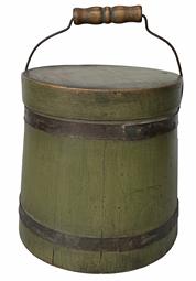 RM1295 Small green painted bale handled firkin. Very sturdy 1/2" thick staved sides are secured by two metal bands. The finger lapped top rim is secured with tiny tacks and staples. Natural patina interior. Circa 1870 - 1890's.  Measurements: 6 1/2" tall (without handle) x 6 7/8" bottom diameter x 6 1/8" top diameter. It is approximately 9 1/4" tall with handle up.