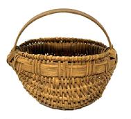 M1107 Fantastic Pennsylvania tightly hand-woven miniature oak splint egg / buttocks basket boasting woven details at the junctures of the two main ribs as well as along the bottom center of the basket. Main juncture of the basket is secured with a tiny tack on each side showing oxidation from age. This wonderful little basket retains original aged, natural patina surface. Great size and condition! Measurements: 3 &frac12;� x 4 &frac14;� diameter x 2 &frac14;� tall (sides) x 3 &frac12;� tall (including handle). 
