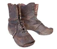 K1876 Pair of 19th century brown leather Childrens Shoes / Boots with very worn, patched soles and toes that are worn completely through. Remnants of shoelaces made from period fabric remain intact. Circa 1860s-1880s. Approximately 6 ½ long x 2 3/8 wide x 5 ½ tall.  