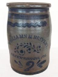 R278 WILLIAMS & REPPERT , GREENSBORO, PA," circa 1885, cylindrical stoneware crock with tooled shoulder and semi-squared rim, decorated with freehand stripes, a stenciled flourishe, and a freehand 2 flanked by flourishes at base.. Excellent condition