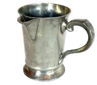 L266C 19th century Pewter Spouted Pitcher - Quart sized - with "ST. JAMES TAVERN" engraved on the bottom. Circa 1837-1850s. This is known as a �One in and two out� or a �You and Me� pitcher. The Innkeeper / Tavern keeper would present this Quart pitcher filled with ale, along with two empty pint-size tankards. The ale was poured from this pitcher into each of the pint size tankards � known as �one for you and one for me.� If additional ale was requested, the Innkeeper / Tavern keeper would refill this pitcher accordingly. Measurements: 4 3/8" diameter base x 6 3/8" tall.