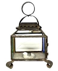 M226 Small sized late 19th century tin candle lantern featuring colorful red, blue green and yellow stained-glass panels and one etched pattern panel. Handmade curled tin feet and a distinctive circular handle atop the decorative hooded top. Singular small sized candle socket inside. Cracks to two panels as seen in photos. Measurements: 7 ¾ x 5 ¼ across feet. Overall height, including ring is ~10 ½ tall.