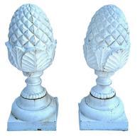 M156 Very early 20th century pair of matching solid cast iron Pineapple finials with geometric diamond shaped details on top and a series of detailed curved leaves and shaped rings below � resting on square bases. Surface retains several layers of old white paint. Extremely heavy.  Circa 1900-1920s. Approximate measurements: Bases are 8� square x ~20 &frac34;� tall.  