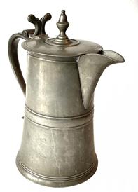 G775 18th century Pewter Flagon / Pitcher / Tankard with prominent spout, acorn finial on lid, distinct curved handle and nicely carved, and shaped thumbpiece on lid. A very tiny engraving on bottom reads "P3116 7/65" - and appears to have been a sort of museum style identification marker. No other marks are evident. No holes. Wonderful surface with great patina. Measurements: 10 3/4" tall x 6" diameter bottom