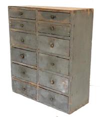 K1515 19th century Pennsylvania twelve (12) drawer original gray painted apothecary. Dovetailed case with the stretchers being mortised into the sides. The drawers are a combination of dovetailed and nailed construction. Circa 1840s-1850s. Measurements:  21 ¾ wide x 9 deep x 25 tall.   