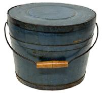 M1144 Identified original blue painted lidded wooden bucket � Stamped on bottom � �Improved and Warranted, by JAMES WHITCHER�.HOOKSET, N H� with arched wire bail handle and turned wooden grip. The thick, solid wood lid is rimmed by a &frac34;� tall metal band secured with hand forged tacks. The interior is old natural patina. Tongue and grooved staved construction held in place with &frac34;� tall metal bands secured with hand forged tacks. Measurements: 11 &frac34;� top diameter x 10� - 10 &frac14;� bottom diameter x 9 &frac14;� tall.