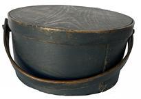 E534 Early 19th century New England wooden bail handle Pantry Box bearing the original dark blue painted surface. Heavy construction with tacked lap joints and a bentwood swing handle that is secured with wooden pegs. Clean, natural patina interior with the initials H A carved inside the lid. Measurements: 13 diameter (top) x 6 ½ tall