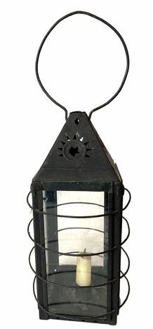 G769 Tin lantern with decorative cut out vents at top of stars, four glass sides  with  four rounded wires around body to protect fingers/hands from hot glass. Sliding metal with glass  door on back raises for access to inside. with candle holder inside 