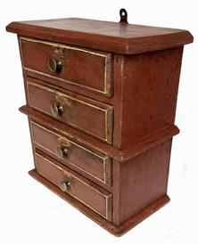 J262 Small hanging stack of drawers bearing early red painted surface with pinstriping on drawer fronts. Drawers are dovetailed. Combination of �T� and wire nail construction. Great wear. Measurements: 10 ¾� wide x 5 ½� deep x 11 ¾� tall 