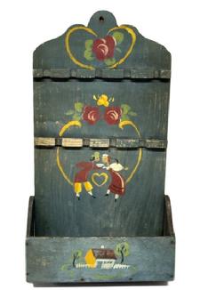 RM1645 Late 19th Century hanging Spoon Rack/ wall Box. One single back board with a cut out design at the top in original blue painted surface with hand painted decorations of Pennsylvania Dutch influence. There are two levels of spoon holders for holding up to a total of nine (9) spoons, over a candle box with shaped sides. The wood is pine with small wire nail construction. Measurements: 9 5/8� wide (back) x 18 &frac12;� tall. The bottom wall box area is 10 &frac14;� wide x 4 &frac14;� deep. 