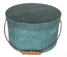 **SOLD** RM1408 19th century New England Bail Handle Pantry Box with the original dry, blue painted surface. Over lapping steamed and bentwood sides are secured with small metal tacks. The sides of the Box are fitted with a pair of oval stamped tin handle mounts and it is fitted with an arched wire swing handle with wooden hand grip. Clean, natural patina interior. Very sturdy. Measurements: 11 ½ diameter across top x 6 ½ tall.