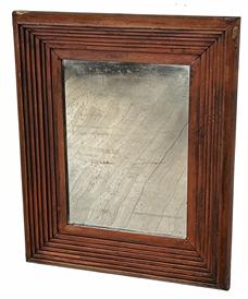 K263 Mid-19th century Pennsylvania looking glass featuring an exceptional stepped molding frame with boldly rounded edges retaining its original bittersweet red painted surface. Appears to be the original silvered mirror. Combination of square head and T nail construction. The wood is pine.