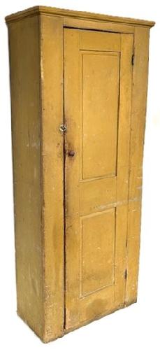 **SOLD** K1827 Early 19th century New England chimney cupboard retaining old mustard painted surface. The door is fully mortised and pegged and boasts two raised panels. Applied molding around the top, and a beaded edge surrounds the door that opens to reveal interior shelving with plate grooves along the back edge of each shelf. Circa 1810  1820s.  The wood is pine. T nails and square head nail construction. Measurements: 31 ¾ wide x 15 ¼ deep x 78 tall (33 ¾ wide x 16 ¼ deep at top molding) 