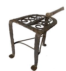 RM1242 Super 18th Century tall, blacksmith hand forged iron tri-footed fireplace trivet resting on broad padded feet with extended wooden handle secured by a wide brass coupling. Prominent hammer marks throughout the iron and wonderful patina to the iron, brass, and wood that is indicative of age.