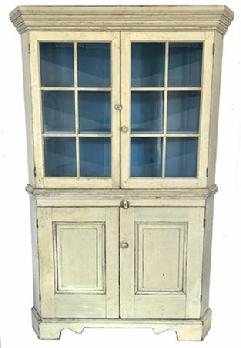H299 19th century western Maryland white painted corner cupboard. One piece. Features two, six-pane glass doors over two raised panel doors below. All doors are fully mortised and pegged. Tall, applied bracket base with decorative cut outs. Wide, stacked cornice molding adorns the top and around the waist molding in center of the cupboard. Square head nail construction. The wood is white pine. Circa 1830�s.