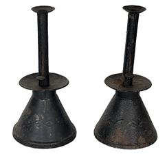 K1506 Unique early pair of handmade sheet iron push-up candlesticks with oversized drip pans and conical shaped, heavily weighted bases bearing punched / embossed decorations and remnants of old black painted surfaces.  Rolled edges with tight soldering joints throughout. From a Pennsylvania collection. (Candles not included) Measurements: 5 ½ diameter (bases) x ~11 tall 