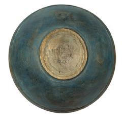 M1128 19th century hand turned wooden bowl bearing early old blue painted surface with prominently lipped rim (~ 1 1/8� tall lip) and evidence of slow lathe turnings throughout. Bowl rests on a slightly raised footed base and retains great natural patina interior with wear indicative of years of use. Out of round. Measurements:  16 &frac34;� x 16 3/8� diameter x ~ &frac34;� thick x 4 &frac12;� � 5 &frac14;� tall (depending on where measured.) Footed area measures 7� x 6 3/8� and is ~3/8� tall.