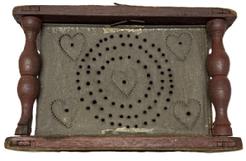 M307 Late 18th to early 19th century Wooden Foot Stove / Foot Warmer bearing original red painted wooden frame, punched tin panels and hand-forged twisted iron bale handle for easy carrying. The fully mortised and pegged wooden frame with turned post corners secures the tin heating chamber that features great folk art punched tin panels bearing punched heart decoration. Retains its original removable rectangular sheet metal cup inside to hold the coal / ashes.  Measurements: 7 5/8� x 9� x 5 &frac34;� tall.  