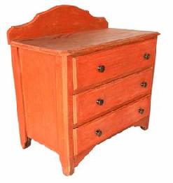 G908 Diminutive mid 19th Century Pennsylvania pumpkin painted chest of drawers featuring backsplash and high decorative feet and three drawers with brass knobs. Square head nail construction. Circa 1850s.