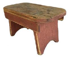 F465 Early 19th century Lancaster County, Pennsylvania mortised stool, in old red paint, high arched cut out sides, with splayed legs and drop aprons on both sides. One board pine wood, square head nail construction.