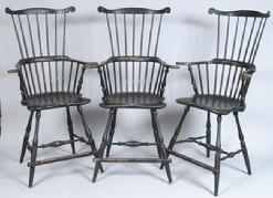 W203 Set of Three W. Wallick (Wrightsville, PA) Windsor Style Counter Stools. Crest rails with carved ears, comb-backs, saddle seats and bulbous H stretchers, turned splayed legs, painted black. Seat height 24 1/2" high, 52" high overall. Condition: very good, with intentional wear.