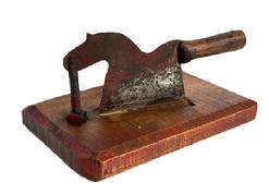 **SOLD** RM1638 19th century tobacco cutter featuring a Horse shaped sheet iron silhouette with wooden handle for the tail. Cutter is mounted on a thick piece of heavy, hand-hewn pine wood that shows remnants of a red washed surface and extensive wear from years of use.
