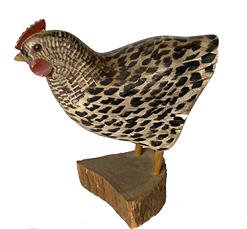 G741 Hand carved primitive folk art wooden replica of a �Barred Rock or Plymouth Rock� chicken with glass eyes and black painted feather details, a short red cone and yellow beak, mounted on a piece of split wood. This is a typical style of the Carver, William Kirkpatrick of Hudson, MA (born in 1939) who�s initials, �WEK�, are branded into bottom of the bird. Excellent condition! Measurements: 9� tall x 8 3/4� long x approximately 2 1/2� wide. The slice of wood is approximately 4� x 4 1/4� x 1 1/2� thick.