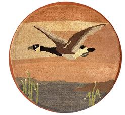 **SOLD** G861 GRENFELL FOLK ART CANADA GOOSE PICTORIAL HOOKED MAT -a circular form depicting a Canada goose flying over a body of water. Tiny colored fabric strips hand-hooked on burlap. Mounted to fabric on a wooden panel for hanging. Grenfell Mission, northern Newfoundland in Labrador, Canada. Circa 1920. Measures 12 3/4" diameter.