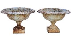 K179 19th century Matching pair of ornate Cast Iron Garden Urns retaining old white painted surfaces. Urns are solid cast iron with leaf patterned rims resting on square bases. Measurements:  21 across tops (openings are 15 ½ diameter) x 7 ¼ square bases x 13 ½ tall 