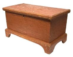 M317 Small 19th century Pennsylvania blanket chest bearing original red painted surface with dovetailed case and applied, dovetailed bracket base with molded edge and cut out feet. Applied molded and mortised edge surrounds the lid. Lidded glove till inside. There are several names, and the date 1887, handwritten inside the chest. Pine, six board construction. Natural patina interior. Measurements: 25 &frac12;� wide x 13� deep x 14� tall. 