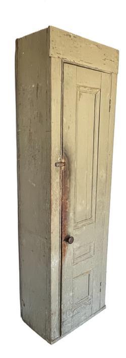 K1511 Early 19th century New England tall Chimney Cupboard in old okra colored painted surface. Cupboard features a fully mortised and pegged single door that opens to a natural patina interior with shelves for storage. Each shelf bears plate grooves on three edges. Applied molding is attached to the sides of the door opening and surrounds each of the three panels on front of door. Great wear and patina from years of use. Circa 1820-1840s. Measurements: 25 &frac12;� wide x 14 &frac34;� deep x 84� (7�) tall. The door is a solid 1 &frac12;� thick.  