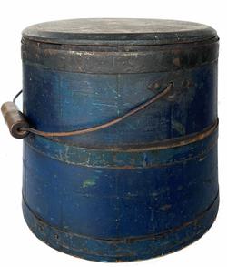 G579 Mid 19th century Shaker original blue painted, lidded wooden sugar bucket featuring iron diamond-shaped bail plates, wire bail with turned wood handle, chamfered bottom and tongue and grooved softwood staved sides secured with three iron bands. Fantastic dark blue paint with great wear and patina on outside and natural patina interior. Measurements: 9 3/4� tall x 9 1/2� diameter top x 11� diameter bottom  