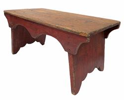 G894  19th century original red painted Chippendale style Stool. with scalloped cut out ends and a single drop front apron, the wood is pine ,nailed construction with square head nails Measurements are:17" long x 8 1/2" tall 9 1/2" wide 