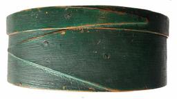 G691 Mid 19th century oval single finger-lapped pantry box in original green paint. Box bears the carved initials �V R� on its top, and prominent brush strokes are visible in the paint.