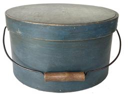 **SOLD** F442 Early 19th century New England bail handle pantry box in original dry blue paint. Heavy construction with overlapping steamed and bentwood sides secured by small tacks.  Original wire bail with wooden handle that retains dark patina from years of use. Interior retains its natural patina surface with various notes handwritten in graphite on inside of lid. Measurements: 11 3/4" diameter x 6 5/8" tall