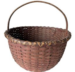 K1626 Sturdy 19th century original dark red painted round woven splint basket with hand-carved steamed and bent handle that is woven into the sides. Double wrapped rim. The tightly woven bottom includes a slightly bumped up interior for airflow. Measurements: 15 top diameter x 16 tall with handle. The sides are ~8 ½ tall. 