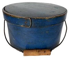 K1736 19th century New England bail handle pantry box bearing original blue paint. Over lapping steamed and bentwood sides secured with small metal tacks. The sides of the box are fitted with a pair of oval stamped tin handle mounts. Fitted with an arched wire swing handle with wooden hand grip. Measurements: 9 ¾ top diameter x 9 1/8 bottom diameter x 5 5/8 tall. 