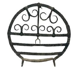 M1152 Fantastic example of early wrought iron hearth ware, this example is exquisite in form and design and dates from the mid to late 18th century, circa 1750-1780. Though this design is commonly referred to as a �Scottish Broiler�. The form is referenced in numerous volumes on period wrought iron, see �The Sorber Collection� by Don Plummer. Also, Wallace Nutting had referenced broilers of a similar nature as the design was carried over by immigrants and travels to America during the period. A broiler such as this was used at the foot of an open-hearth fireplace. A cut of meat, or a fowl would have been placed on the face of the broiler. The back standing leg would have allowed the piece to angle against the flames of the heat and allow for direct cooking. As you can see, this example carries a wonderful series of curled decorations that would not only function as a support but also absorb the radiant heat and allow for a more uniform cooking platform. Measurements: 18 &frac14;� wide x 18� tall. 