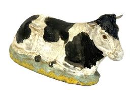 M1163 Resting Holstein Cow with glass eyes and wooden horns � Marked �Made in Germany� on bottom. Constructed of papier mache composition material. Circa 1920s-1930s. Approximate measurements: 8 &frac14;� long x 2 &frac12;� wide x 4� tall.   