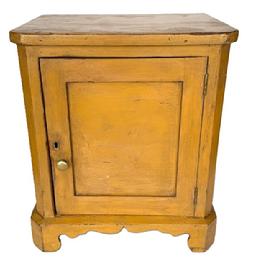 **SOLD** L130 Sweet 19th century Pennsylvania small countertop one door cupboard in original mustard paint - with chamfered corners and applied bracket base with decorative cut out feet. The following is written in pencil inside the left side of this little cupboard: 1885 July Aggie Foran Saturday - 11 years old and 1885 is written in pencil on the interior of the back board. Clean, natural patina interior. The door is mortised and wooden pegged construction. The wood is pine, square head nail construction. Measurements: 16 wide x 12 ¼ deep x 18 5/8 tall.