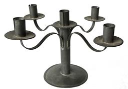 RM1495 Early solid tin round candelabra featuring four delicately curved, rolled edged arms extending from a center post. There are a total of five candle cups � each with nicely rolled edges soldered to a drip cup that features a singular crimped edge that matches the base. All soldered joints are secure.  Approximate measurements: 5 ½� diameter base x 8� tall x ~14� across