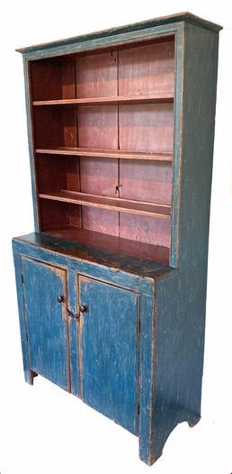 G343 Early 19th century one piece open top Pennsylvania stepback Cupboard, Painted pine stepback cupboard, ca. 1800, retaining an old blue surface with red interior, open top over two plank door with high cut out feet, nice single bead around doors as well as the open top