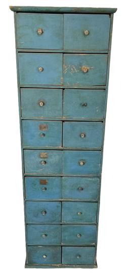 **SOLD** K1794 Late 19th century Pennsylvania Country Store 18-drawer Apothecary. Unique tall, slender configuration with original brass hardware retaining an old blue painted surface. Remnants of labels remain on a few of the drawer fronts. Wire nails and a few square head nail construction with drawer stretchers being mortised into the sides. The wood is poplar. Circa 1870.Measurements: 19 wide x 13 deep x 59 ¾ tall.   