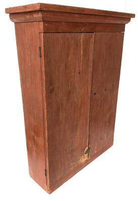 G405 19th century Pennsylvania Hanging Cupboard in the original dry red paint, circa 1850 two planks doors with applied molding, the interior has two shelves which are mortised into the sides, two wide walnut back board held in pace with square head nails